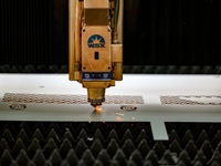 A worker produces a fiber laser cutting machine on a flexible production line in a digital production workshop in the West Coast New Area of...