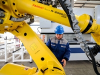 A worker produces a fiber laser cutting machine on a flexible production line in a digital production workshop in the West Coast New Area of...