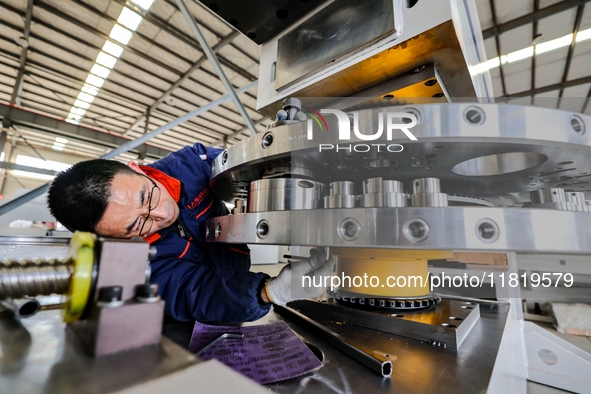 A worker produces a fiber laser cutting machine on a flexible production line in a digital production workshop in the West Coast New Area of...