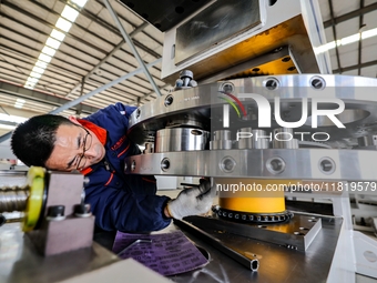 A worker produces a fiber laser cutting machine on a flexible production line in a digital production workshop in the West Coast New Area of...