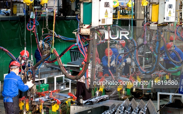 Workers produce shuttleless looms at a workshop in the West Coast New Area of Qingdao, Shandong province, China, on November 28, 2024. 