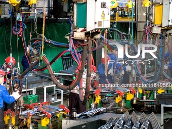 Workers produce shuttleless looms at a workshop in the West Coast New Area of Qingdao, Shandong province, China, on November 28, 2024. (