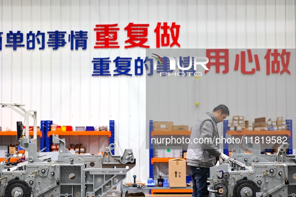 Workers produce shuttleless looms at a workshop in the West Coast New Area of Qingdao, Shandong province, China, on November 28, 2024. 