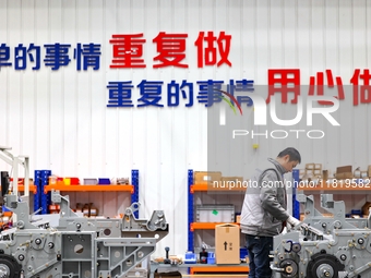 Workers produce shuttleless looms at a workshop in the West Coast New Area of Qingdao, Shandong province, China, on November 28, 2024. (