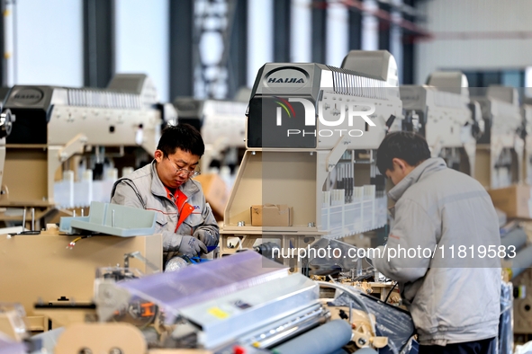 Workers produce shuttleless looms at a workshop in the West Coast New Area of Qingdao, Shandong province, China, on November 28, 2024. 