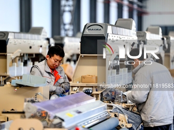 Workers produce shuttleless looms at a workshop in the West Coast New Area of Qingdao, Shandong province, China, on November 28, 2024. (