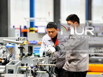 Workers produce shuttleless looms at a workshop in the West Coast New Area of Qingdao, Shandong province, China, on November 28, 2024. (