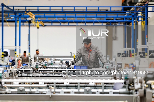 Workers produce shuttleless looms at a workshop in the West Coast New Area of Qingdao, Shandong province, China, on November 28, 2024. 