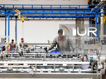 Workers produce shuttleless looms at a workshop in the West Coast New Area of Qingdao, Shandong province, China, on November 28, 2024. (