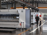 Workers produce shuttleless looms at a workshop in the West Coast New Area of Qingdao, Shandong province, China, on November 28, 2024. (