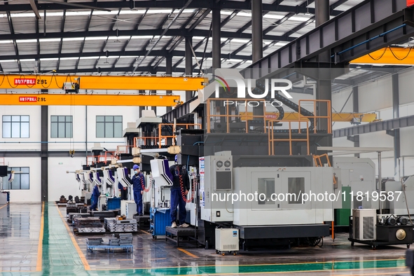 Workers produce shuttleless looms at a workshop in the West Coast New Area of Qingdao, Shandong province, China, on November 28, 2024. 