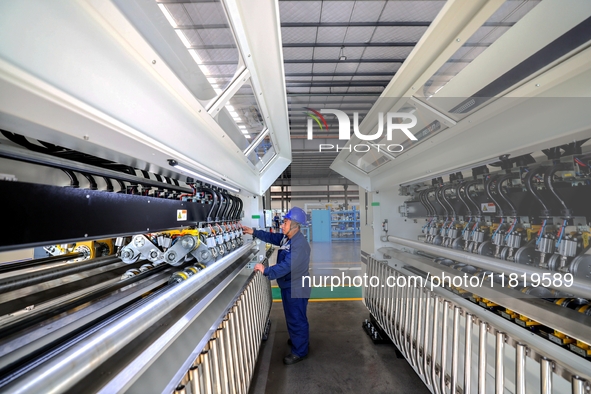 Workers produce shuttleless looms at a workshop in the West Coast New Area of Qingdao, Shandong province, China, on November 28, 2024. 