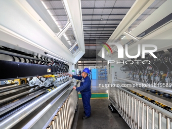 Workers produce shuttleless looms at a workshop in the West Coast New Area of Qingdao, Shandong province, China, on November 28, 2024. (