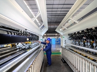 Workers produce shuttleless looms at a workshop in the West Coast New Area of Qingdao, Shandong province, China, on November 28, 2024. (