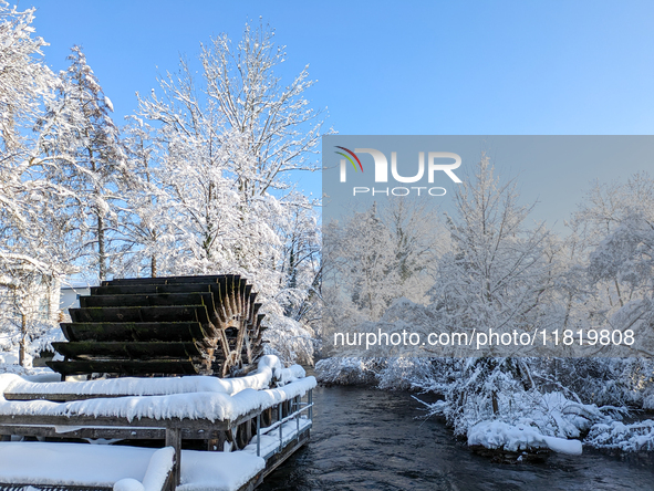 The old Mill Wheel on the River Wurm in Gauting, Germany, on December 3, 2023, is covered in snow. 