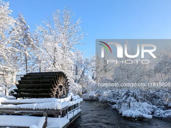 The old Mill Wheel on the River Wurm in Gauting, Germany, on December 3, 2023, is covered in snow. (