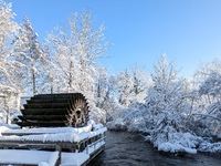 The old Mill Wheel on the River Wurm in Gauting, Germany, on December 3, 2023, is covered in snow. (