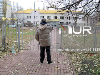 A man looks at a family polyclinic in the Dniprovskyi district damaged by an overnight Russian drone attack in Kyiv, Ukraine, on November 29...