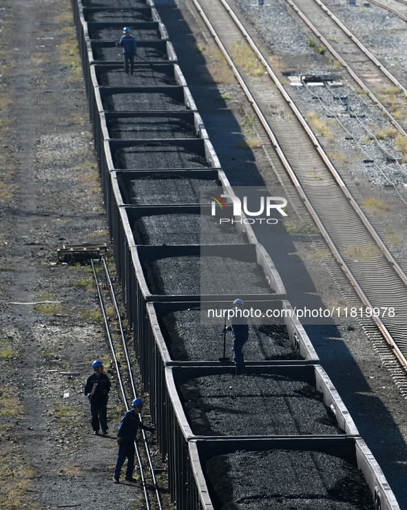 Workers smooth electrical coal at a special railway line of Jiangxi Coal Reserve Center in Jiujiang, Jiangxi province, China, on November 29...