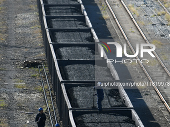 Workers smooth electrical coal at a special railway line of Jiangxi Coal Reserve Center in Jiujiang, Jiangxi province, China, on November 29...