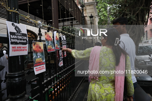 People look at posters while monks of ISKCON (International Society of Krishna Consciousness) and Hindu devotees in Kolkata hold a protest a...