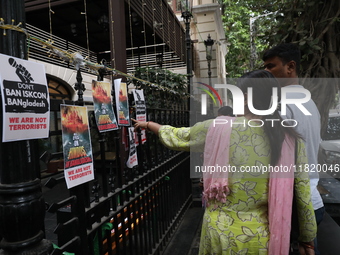 People look at posters while monks of ISKCON (International Society of Krishna Consciousness) and Hindu devotees in Kolkata hold a protest a...