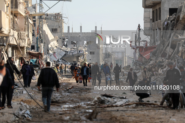 Palestinians inspect the destruction as displaced residents return to Nuseirat in the central Gaza Strip after Israeli shelling of the camp...