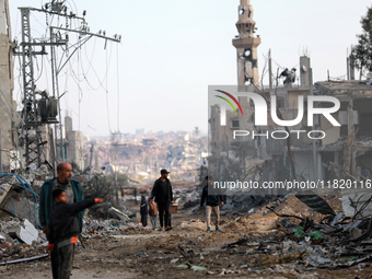 Palestinians inspect the destruction as displaced residents return to Nuseirat in the central Gaza Strip after Israeli shelling of the camp...