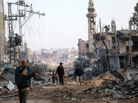 Palestinians inspect the destruction as displaced residents return to Nuseirat in the central Gaza Strip after Israeli shelling of the camp...