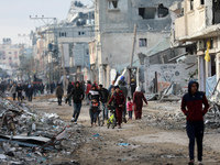 Palestinians inspect the destruction as displaced residents return to Nuseirat in the central Gaza Strip after Israeli shelling of the camp...