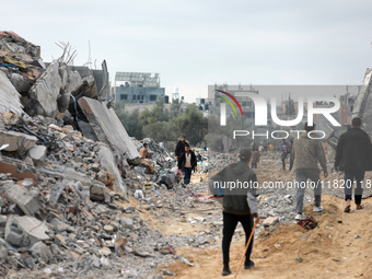 Palestinians inspect the destruction as displaced residents return to Nuseirat in the central Gaza Strip after Israeli shelling of the camp...