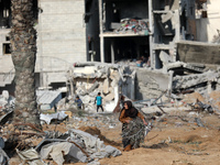 Palestinians inspect the destruction as displaced residents return to Nuseirat in the central Gaza Strip after Israeli shelling of the camp...