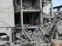 Palestinians inspect the destruction as displaced residents return to Nuseirat in the central Gaza Strip after Israeli shelling of the camp...