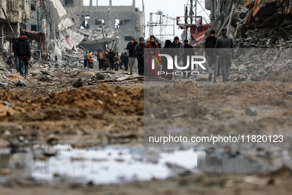 Palestinians inspect the destruction as displaced residents return to Nuseirat in the central Gaza Strip after Israeli shelling of the camp...