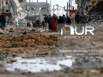 Palestinians inspect the destruction as displaced residents return to Nuseirat in the central Gaza Strip after Israeli shelling of the camp...