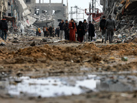 Palestinians inspect the destruction as displaced residents return to Nuseirat in the central Gaza Strip after Israeli shelling of the camp...