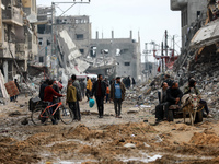 Palestinians inspect the destruction as displaced residents return to Nuseirat in the central Gaza Strip after Israeli shelling of the camp...