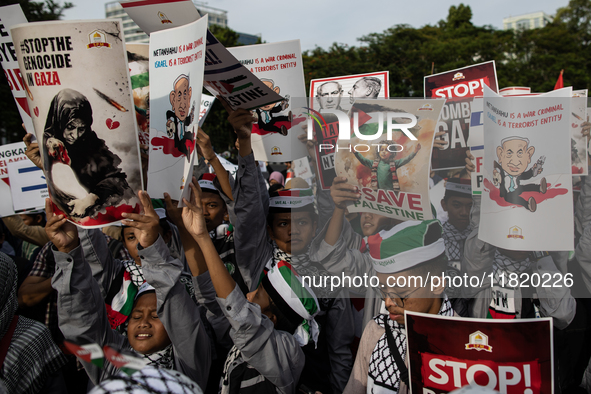 Indonesian people shout slogans and hold placards during a pro-Palestinian demonstration in front of the US Embassy in Jakarta, Indonesia, o...