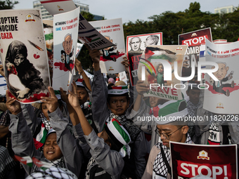 Indonesian people shout slogans and hold placards during a pro-Palestinian demonstration in front of the US Embassy in Jakarta, Indonesia, o...