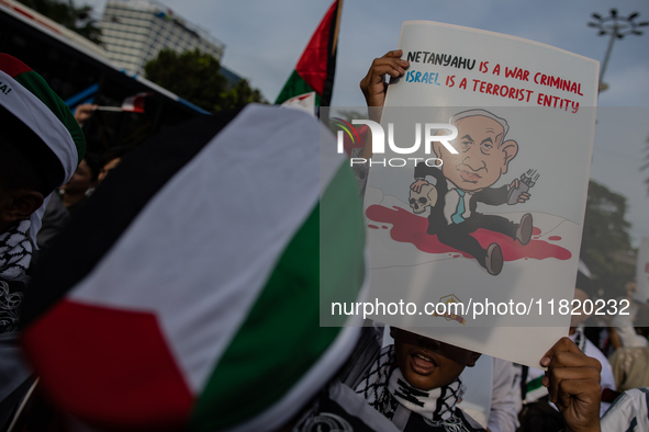 Indonesian people shout slogans and hold placards during a pro-Palestinian demonstration in front of the US Embassy in Jakarta, Indonesia, o...