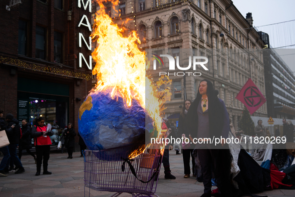 Activists from Elokapina, or Extinction Rebellion Finland, protest against Black Friday in Helsinki, Finland, on November 29, 2024. The acti...