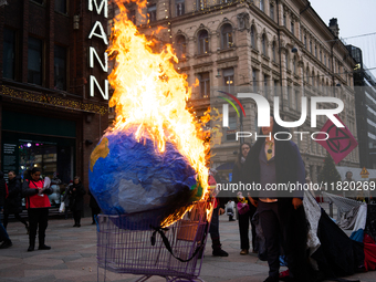 Activists from Elokapina, or Extinction Rebellion Finland, protest against Black Friday in Helsinki, Finland, on November 29, 2024. The acti...