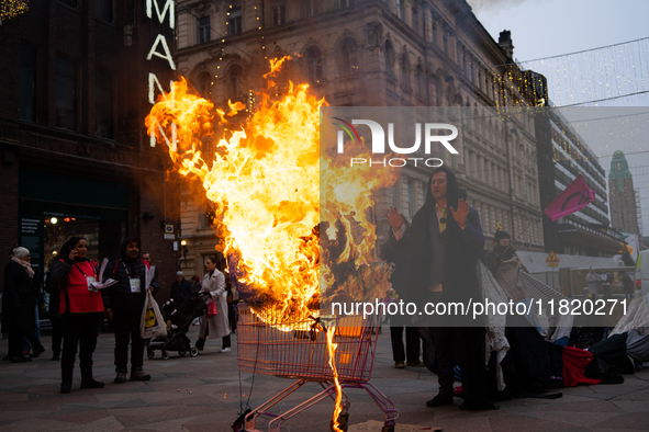 Activists from Elokapina, or Extinction Rebellion Finland, protest against Black Friday in Helsinki, Finland, on November 29, 2024. The acti...