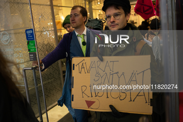 Activists from Elokapina, or Extinction Rebellion Finland, protest against Black Friday in Helsinki, Finland, on November 29, 2024. The acti...