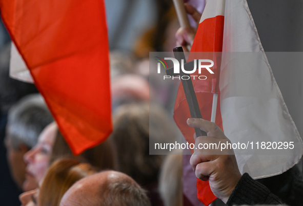 KRAKOW, POLAND - NOVEMBER 24:
One of the party supporters holds a Polish flag and a cross at the event where Karol Nawrocki was nominated as...