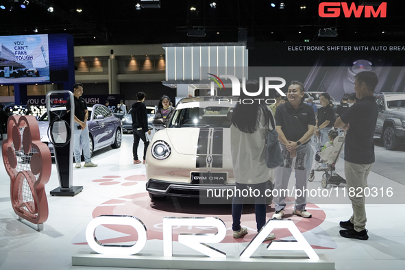 Visitors inspect a GWM ORA electric car displayed at the Thailand International Motor Expo 2024 at the IMPACT exhibition center in Bangkok,...