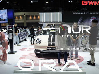 Visitors inspect a GWM ORA electric car displayed at the Thailand International Motor Expo 2024 at the IMPACT exhibition center in Bangkok,...