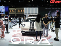 Visitors inspect a GWM ORA electric car displayed at the Thailand International Motor Expo 2024 at the IMPACT exhibition center in Bangkok,...