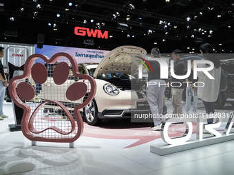 Visitors inspect a GWM ORA electric car displayed at the Thailand International Motor Expo 2024 at the IMPACT exhibition center in Bangkok,...