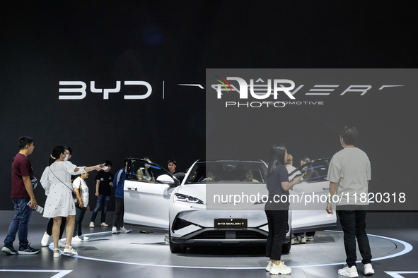 Visitors inspect a BYD SEALION 7 electric car displayed at the Thailand International Motor Expo 2024 at IMPACT exhibition center in Bangkok...